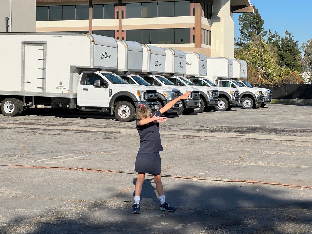 Mat Men fleet of Sunset trucks with young fan